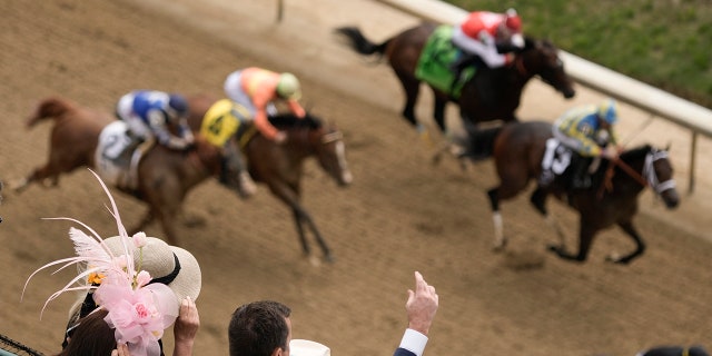 People react while watching a horse race.