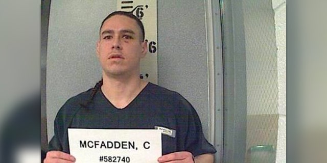 Cody McFadden holds a name plate in mug shot