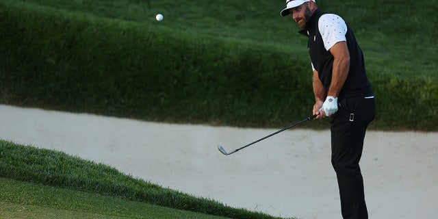 Dustin Johnson chips on the 13th green