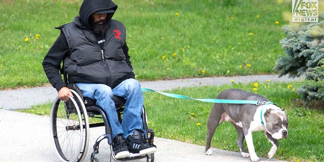 Edward Holley walks his dog outside his home in Middeltown