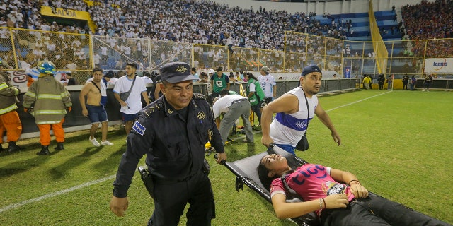 aid workers carrying woman on stretcher