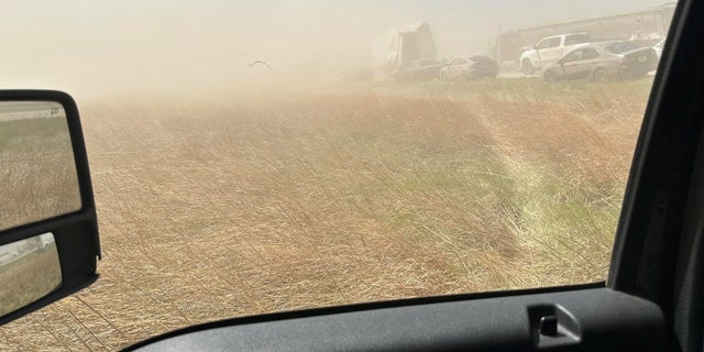 A field and cars in a dust storm