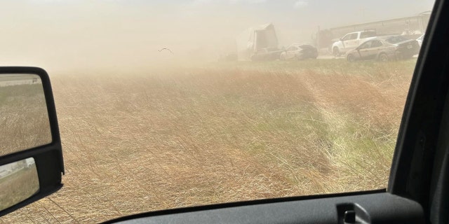 A field and cars in a dust storm