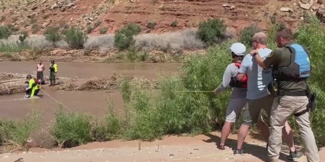 rescuers ready to pull boy across river