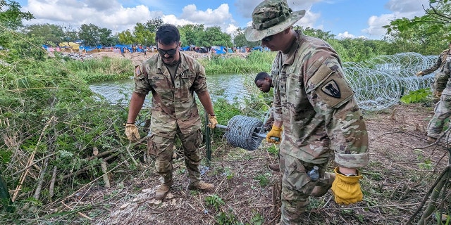 Troops walking along the border, laying wire