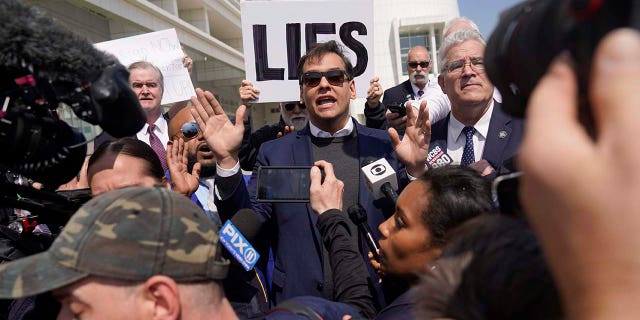 US Representative George Santos is surrounded by media as he leaves the federal courthouse