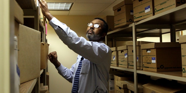 Man searches for records in a vault.