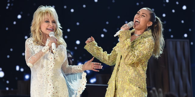 Dolly Parton in white suite performs with Miley Cyrus in gold suit