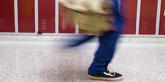 student walking by locker