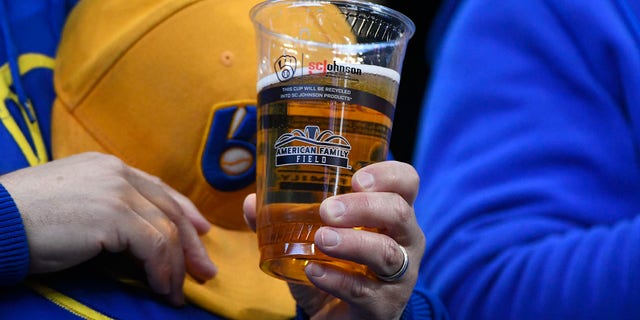 Fan holds a beer at a Brewers game