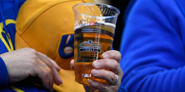 Fan holds a beer at a Brewers game