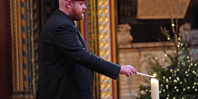 tom walker lighting a candle at christmas concert