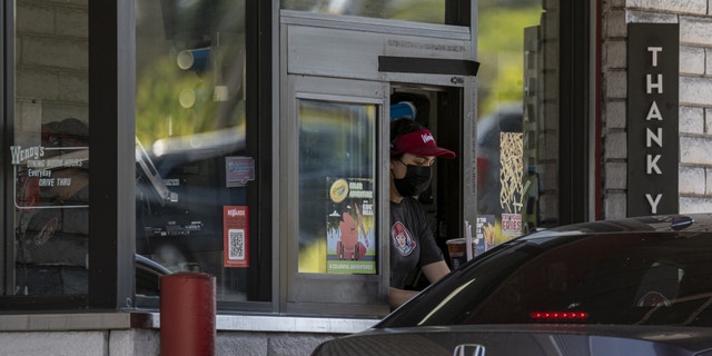 Drive thru window at a Wendy's with a customer in line.