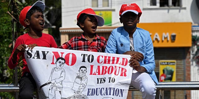 los niños sostienen un cartel en la manifestación contra el trabajo infantil