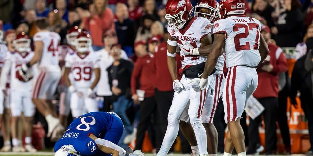 Razorbacks cornerback Quincey McAdoo celebrates tackling a Jayhawks player