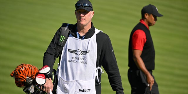 Tiger Woods walks with caddy Joe LaCava at The Genesis Invitational