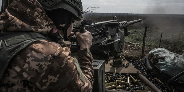 Ukrainian soldiers fire on the front line