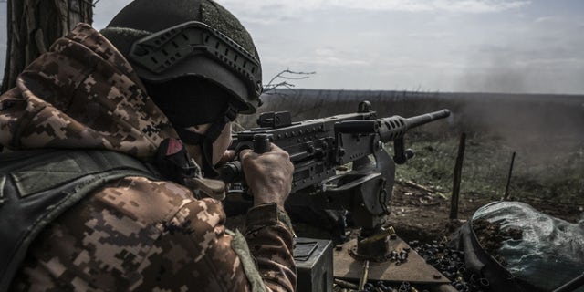 Ukrainian soldiers fire on the front line