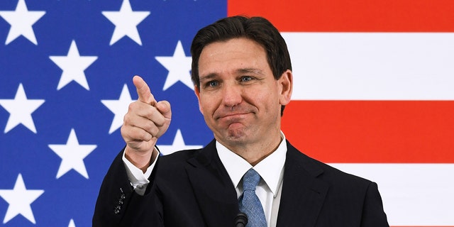 DeSantis pointing with an American flag in the background