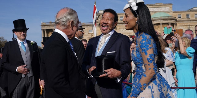 King Charles with his back to the camera shares a laugh with Lionel Richie and his girlfriend Lisa Parigi at the Garden Party at Buckingham Palace ahead of the coronation