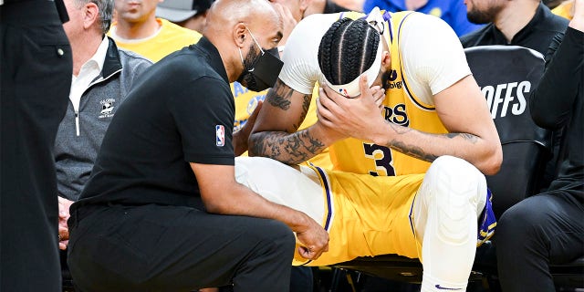Anthony Davis gets checked by a trainer