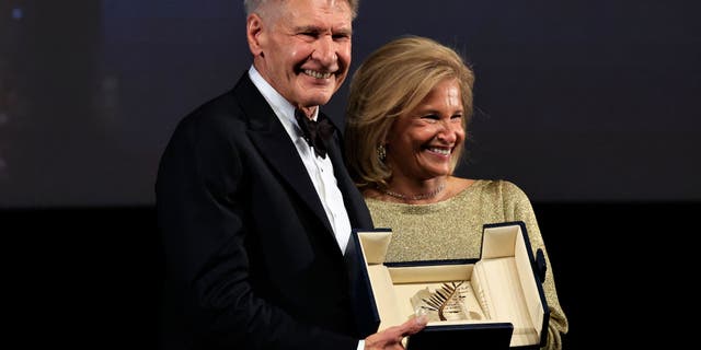 Harrison Ford in a tuxedo receiving a Palme d'Or