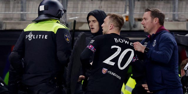 A West Ham United player is held back during a brawl in the stands