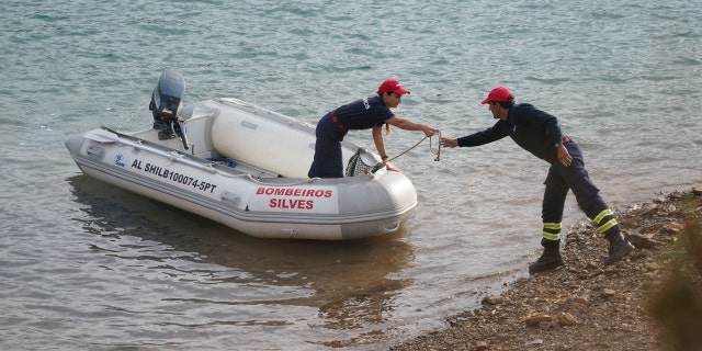 Investigators on a boat in the Arade dam