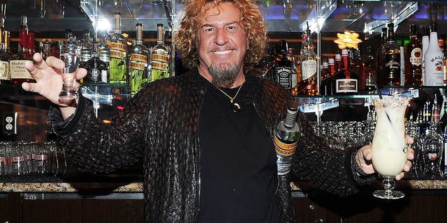 sammy hagar holding shot glass, drink and bottle of rum