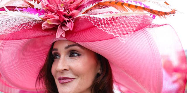 A large pink derby hat on a woman's head