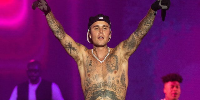 Justin Bieber performs onstage shirtless