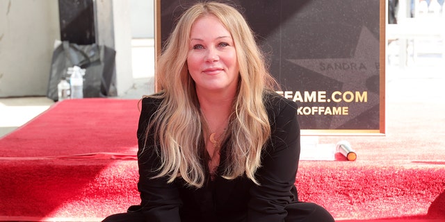 Christina Applegate sitting next to her star on the walk of fame