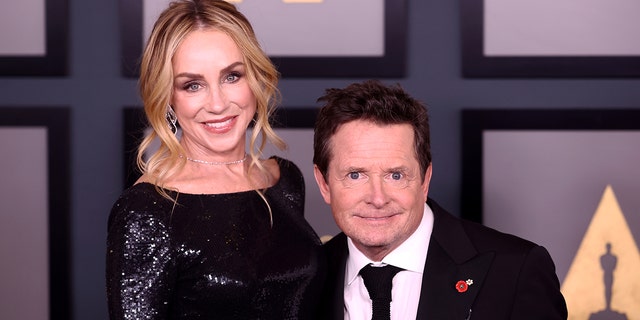 Michael J. Fox poses for a photo with wife Tracy on the red carpet at the Academy of Motion Picture Arts and Sciences - he is significantly shorter than her