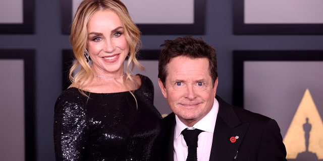 Michael J. Fox poses for a photo with wife Tracy on the red carpet at the Academy of Motion Picture Arts and Sciences - he is significantly shorter than her