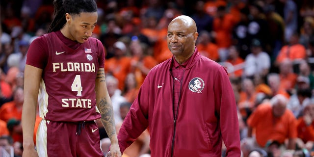 Caleb Mills habla con el entrenador en jefe Leonard Hamilton