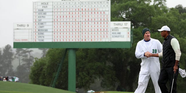 Tiger Woods and Joe LaCava walk the green at Augusta National