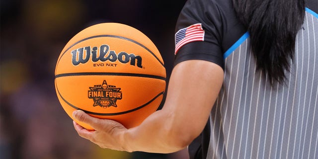 referee holds the game ball during the national championship game