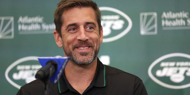 Aaron Rodgers behind the podium as he is announced as the New York Jets newest QB