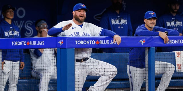 Blue Jays manager John Schneider stands next to Pete Walker