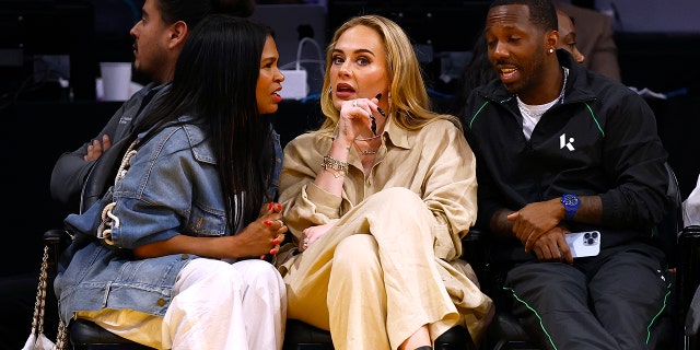 Nia Long faces Adele as they engage in conversation courtside at the Laker's game, while Rich Paul looks on