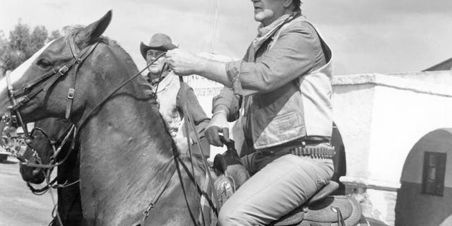 John Wayne on horseback in a scene from Rio Lobo