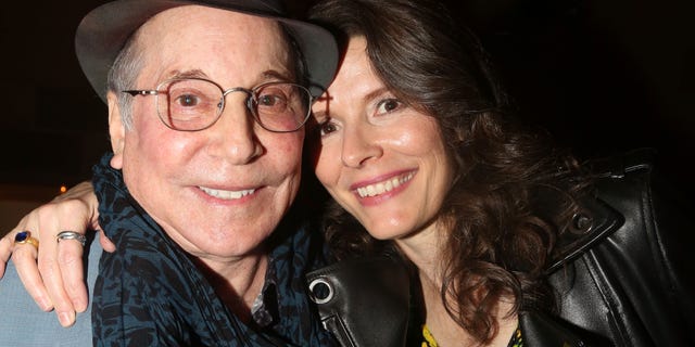 Paul Simon and wife Edie Brickell smiling in close up