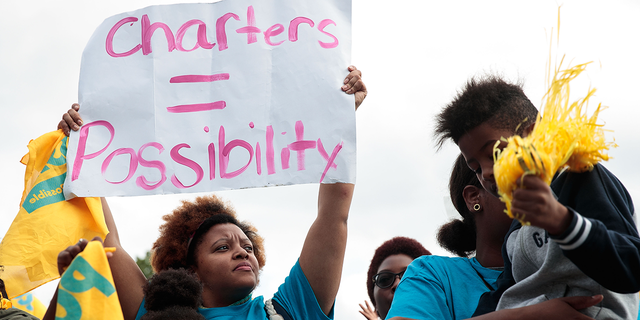 A woman with a school choice protest sign