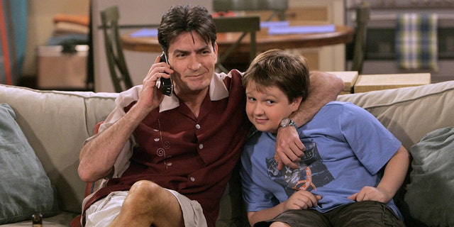 Charlie Sheen raps his arm around a young Angus T. Jones on the set of "Two and a Half Men" 