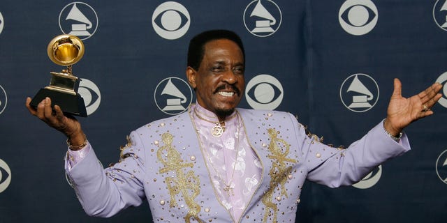 Ike Turner in a purple suit holding his grammy