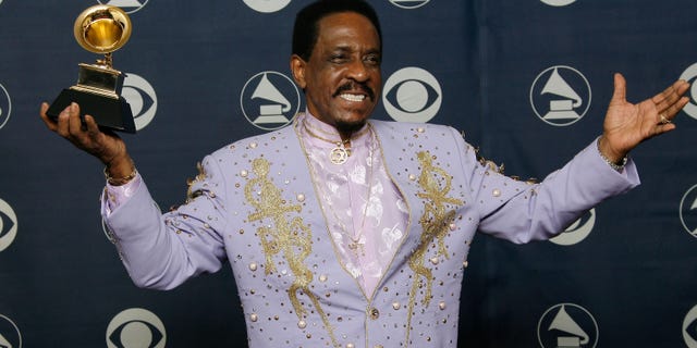 Ike Turner in a purple suit holding his grammy