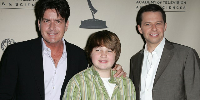 Charlie Sheen holds on to Angus T. Jones next to Jon Cryer at an event for "Two and a Half Men"