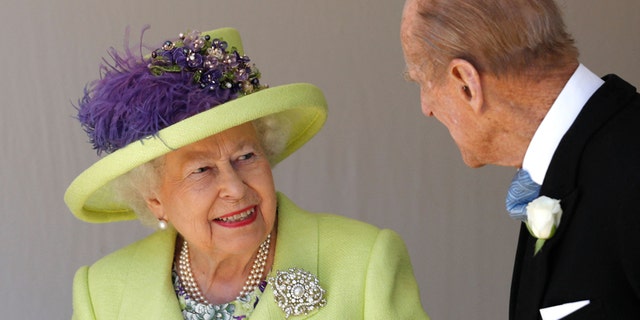 Queen Elizabeth smiles in a key-lime green jacket and matching hat at Prince Philip at George's Chapel after the wedding between Prince Harry and Meghan Markle