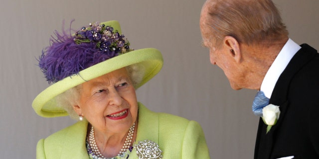 Queen Elizabeth smiles in a key-lime green jacket and matching hat at Prince Philip at George's Chapel after the wedding between Prince Harry and Meghan Markle