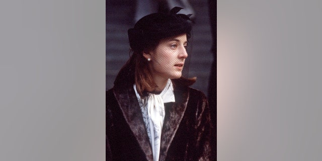 Lady Amanda Knatchbull in a dark coat and white blouse looking away from the camera